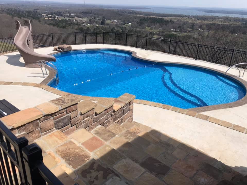 A large swimming pool with a slide on the side of it