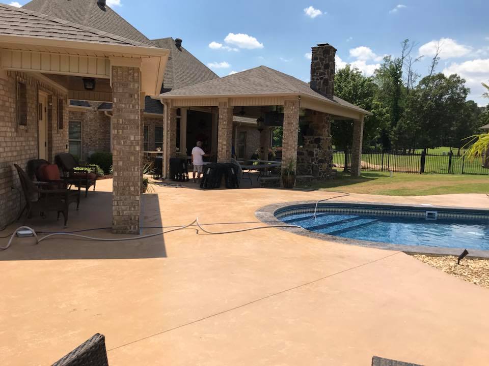 There is a large swimming pool in the backyard of a house.