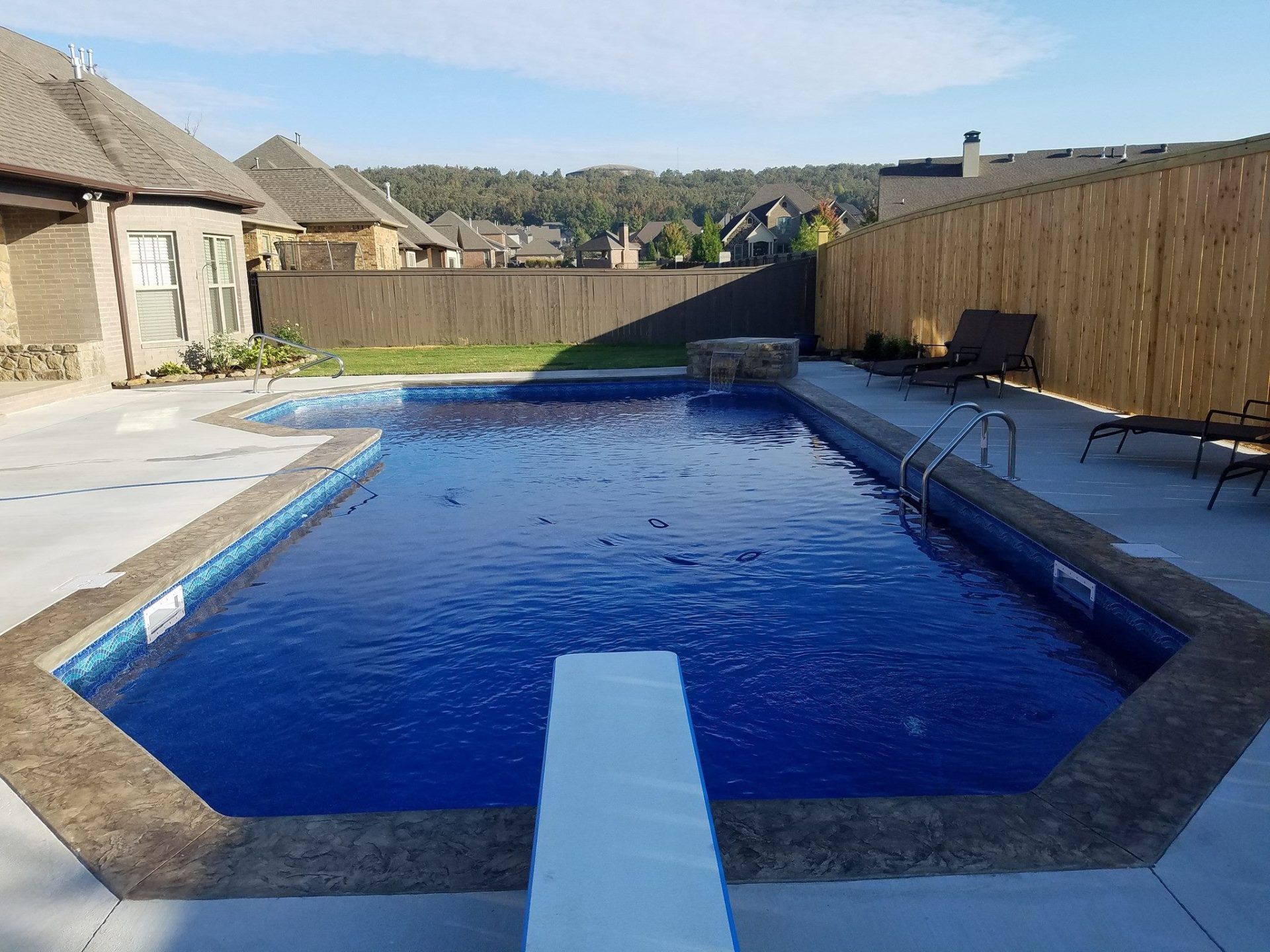 A large swimming pool with a diving board in the middle of it.