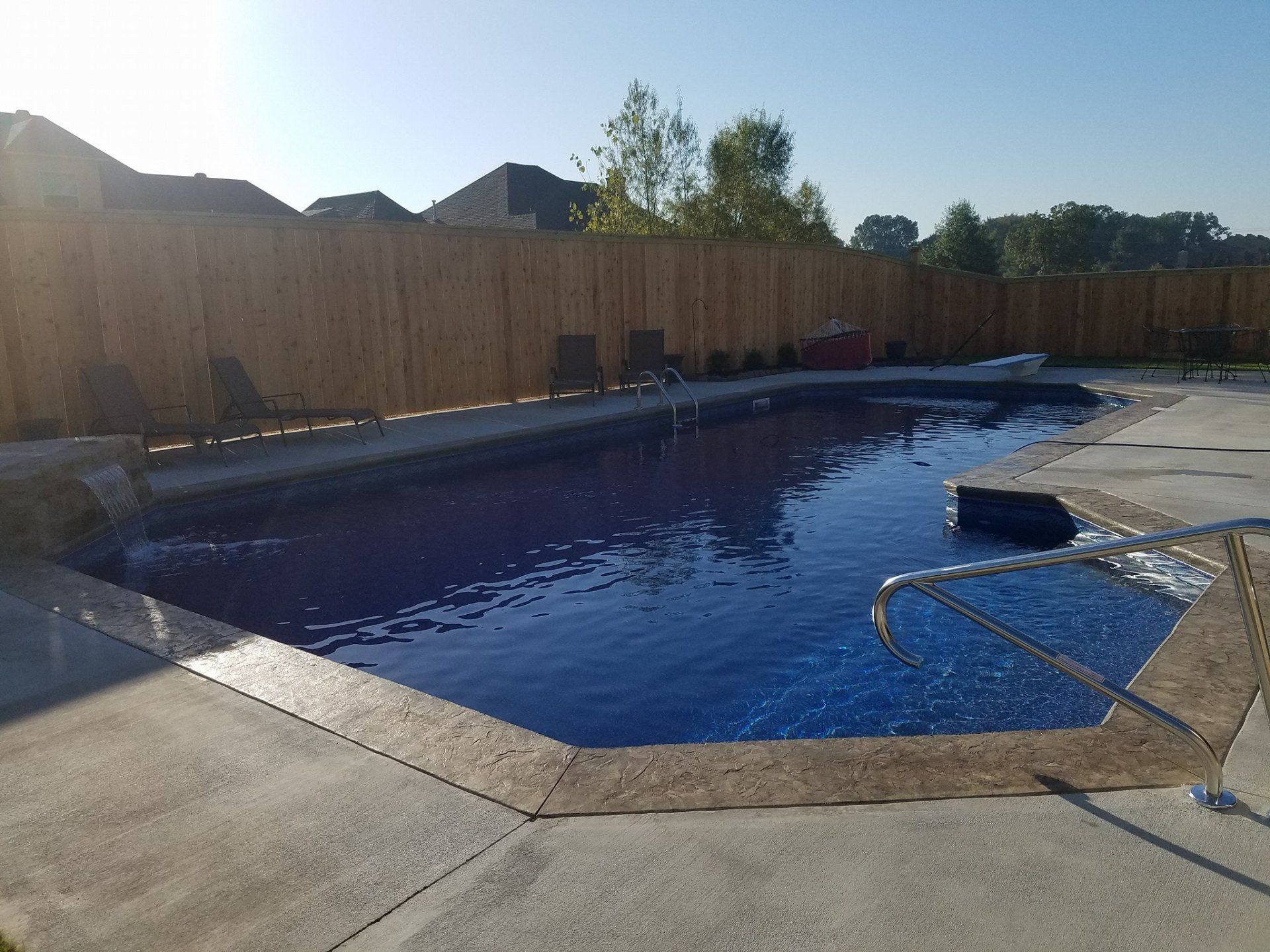 A large swimming pool with a wooden fence around it
