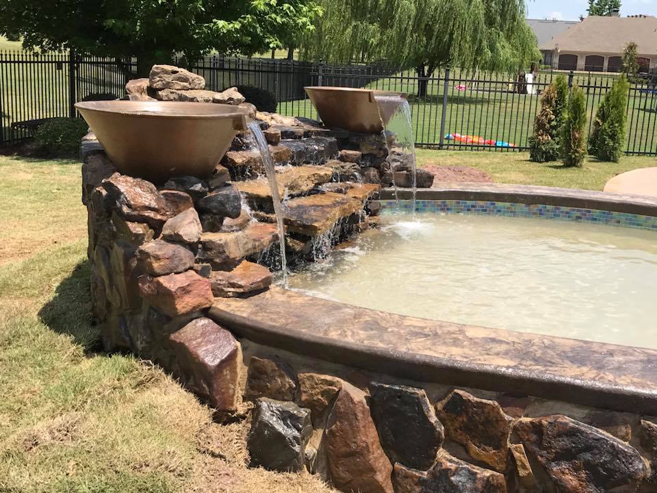 There is a waterfall in the middle of a pool surrounded by rocks.