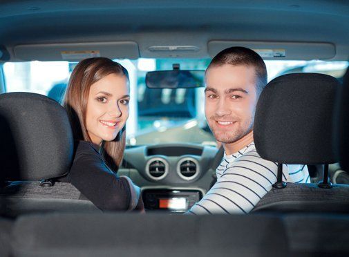 happy couple driving a car 