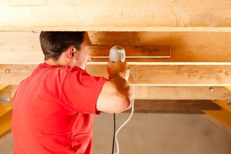 operaio che esegue un lavoro di coibentazione del tetto