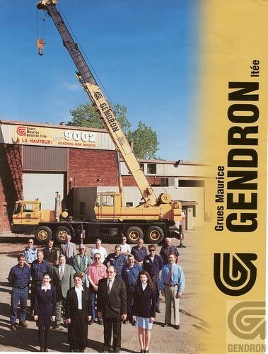 A group of people standing in front of a truck with a crane on it
