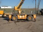A yellow crane is parked in a parking lot.