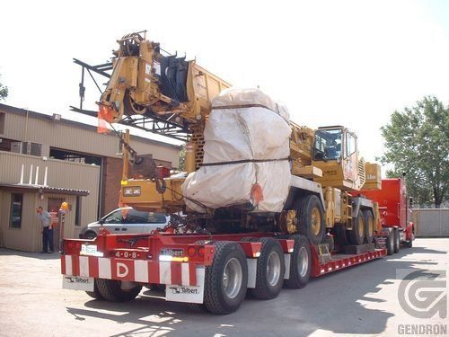 A semi truck with a crane on the back of it