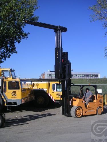 A man is driving a forklift in a parking lot