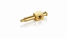 A small brass object is sitting on a white surface.