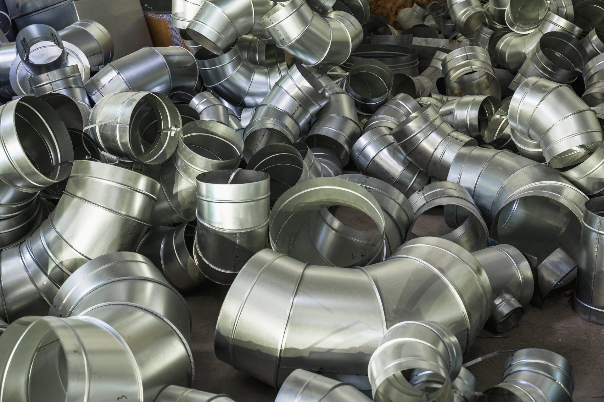 A pile of metal pipes are laying on the floor.