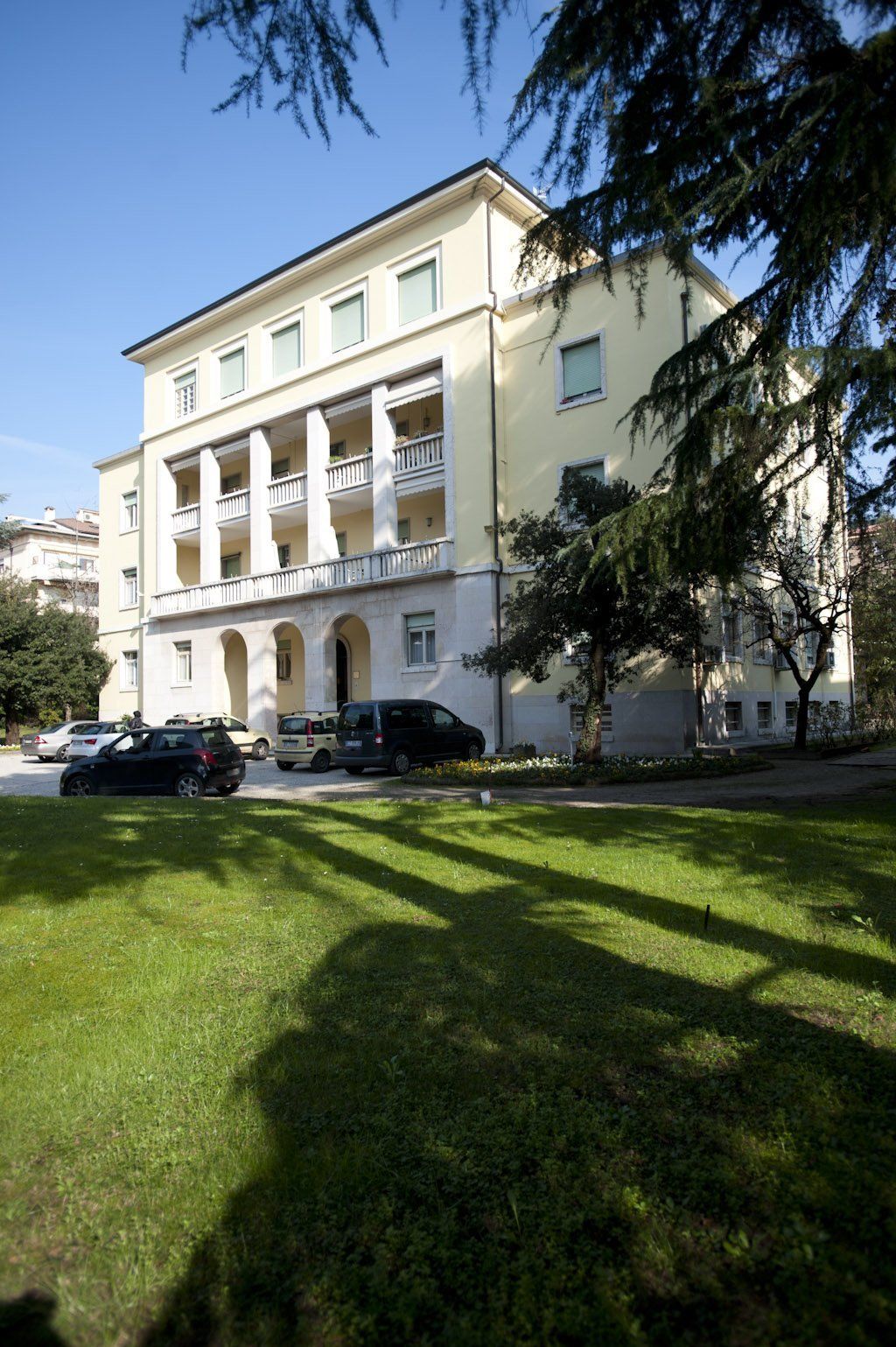 residenza per anziani con facciata gialla e distesa verde con alberi