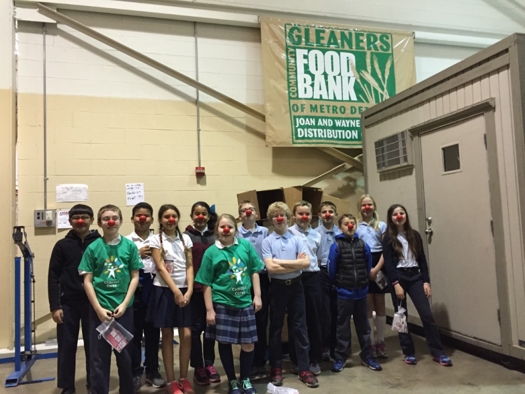 A group of children are posing for a picture in front of a sign that says food bank