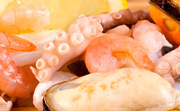 Close-up of assorted seafood, including shrimp, octopus, and mussels.