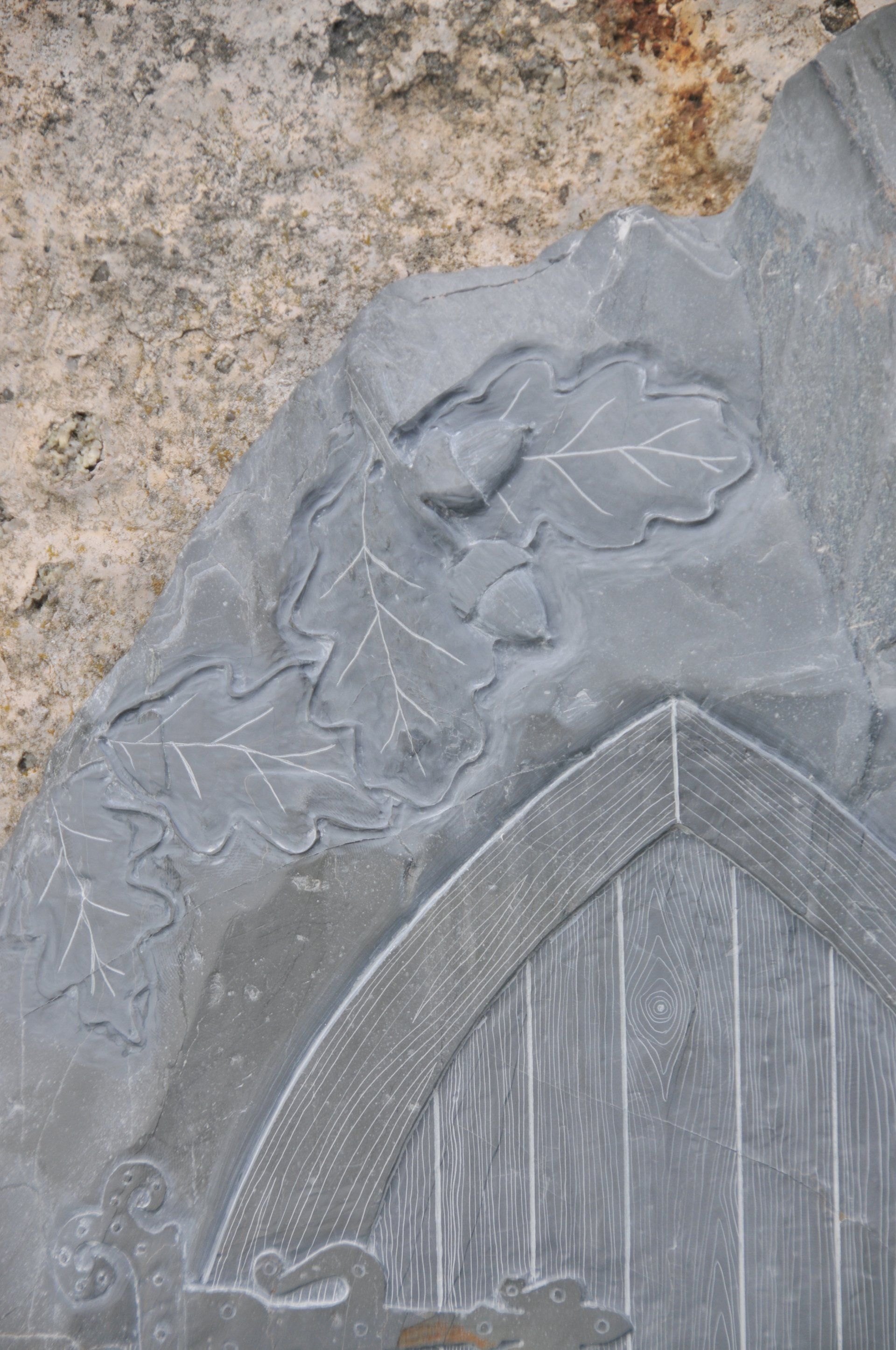 Oak leaves and acorn details from a large fairy door hand engraved using a Devonian mudstone beach stone.
