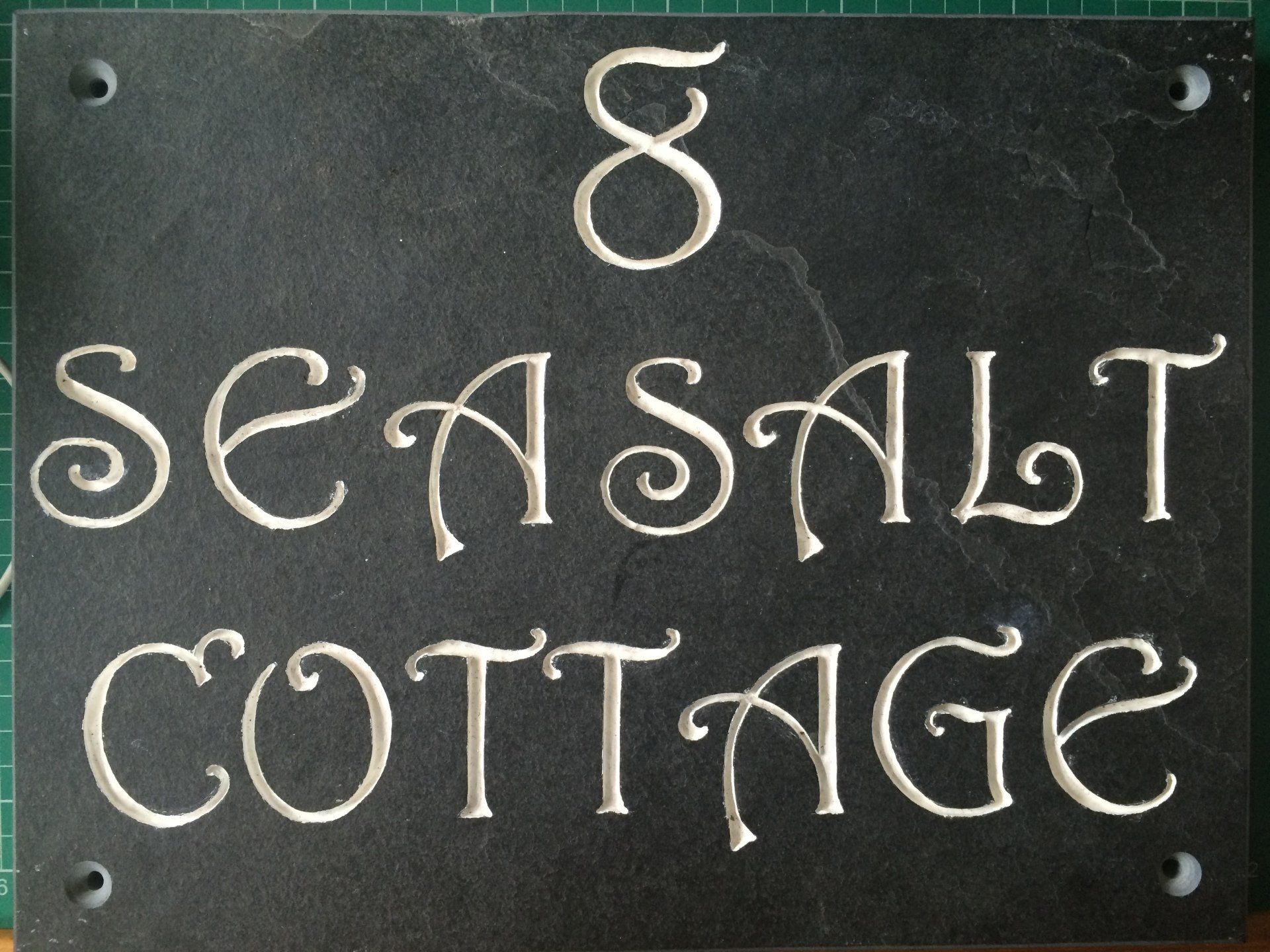 8 Seasalt Cottage in slate painted with gloss white enamel paint using Harrington font.
House Signs by Slate of the Art
Hand Engraved House Signs
Made in Porthleven
Hand Made in Cornwall
Hand Made House Signs