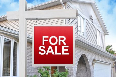 A home is advertising a for sale sign on a wooden sign post in red A home is advertising a for sale sign on a wooden sign post in red