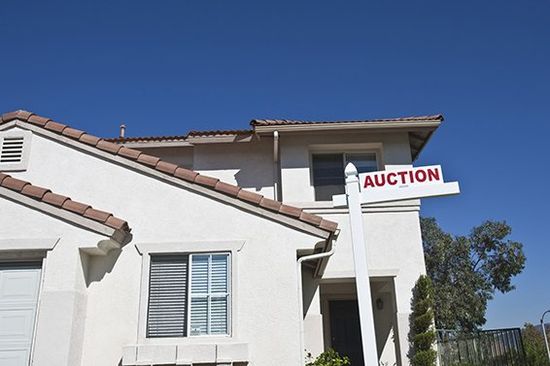 House with auction Sign against blue sky House with auction Sign against blue sky
