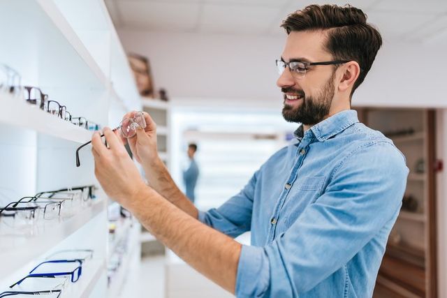 Optometrist Office — Young Man Chooses Eyeglasses in  San Antonio, TX
