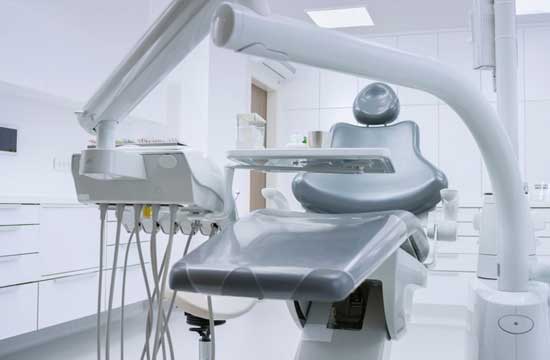 Empty dentist chair and equipment in dental office.