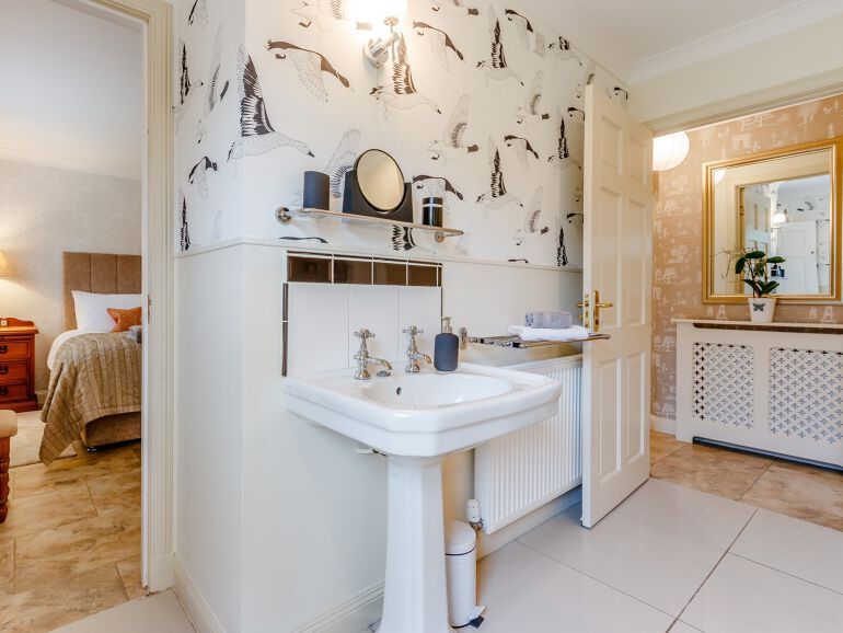 White sink with open doorways to hallway and bedroom