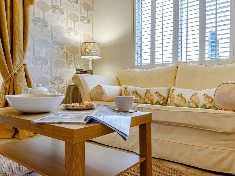 Wooden coffee table in foreground with cream sofa behind