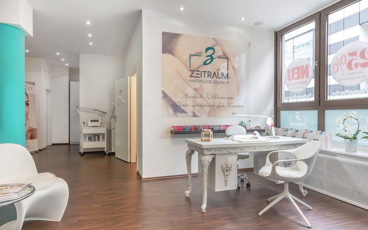 Innenansicht eines Nagelstudios. Zu sehen sind ein weißer Schreibtisch mit zwei Stühlen, Nagellackproben und eine große Werbung.