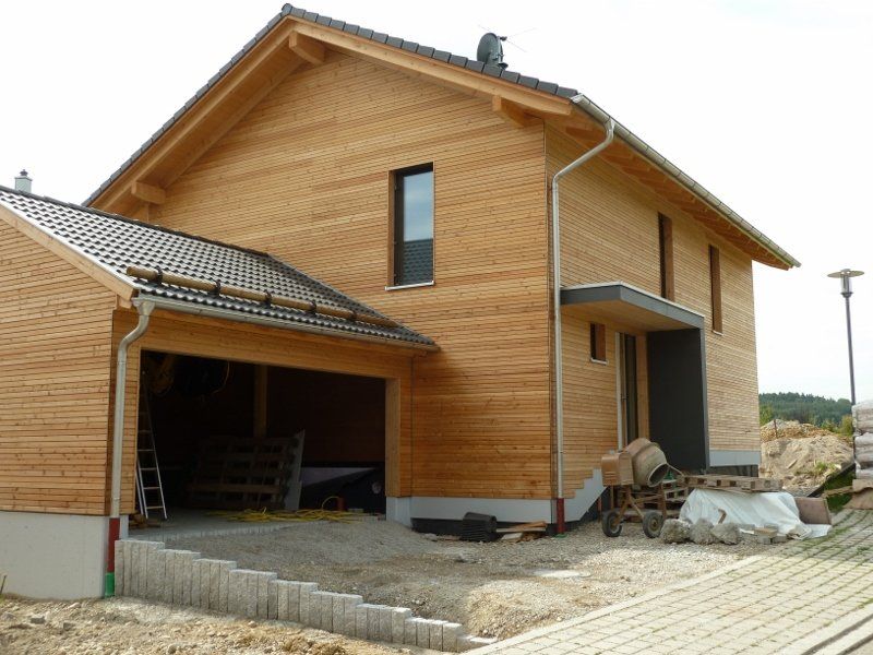 A wooden house with a garage underneath it