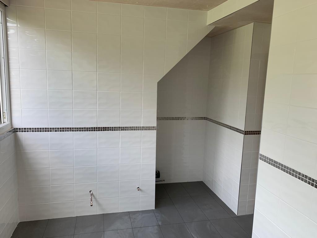 Empty bathroom with tiled walls