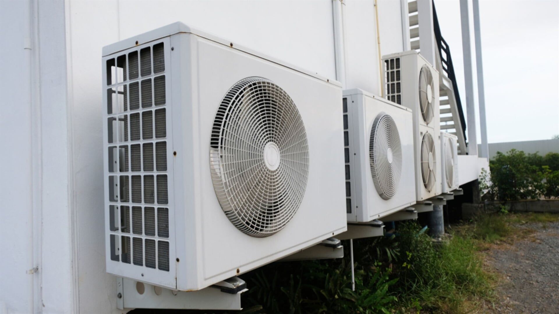 Quality Air Conditioners — Air Conditioner Cleaning In Cairns, QLD A Row of Air Conditioners on the Side of a Building — Air-Con Cleaning Specialists in Redlynch, QLD