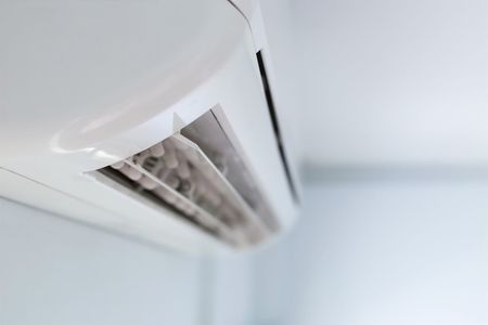 A Close Up of a White Air Conditioner Hanging on a Wall — Air-Con Cleaning Specialists in Redlynch, QLD