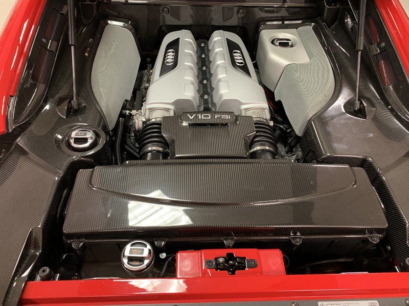 The engine of a red sports car with the hood open