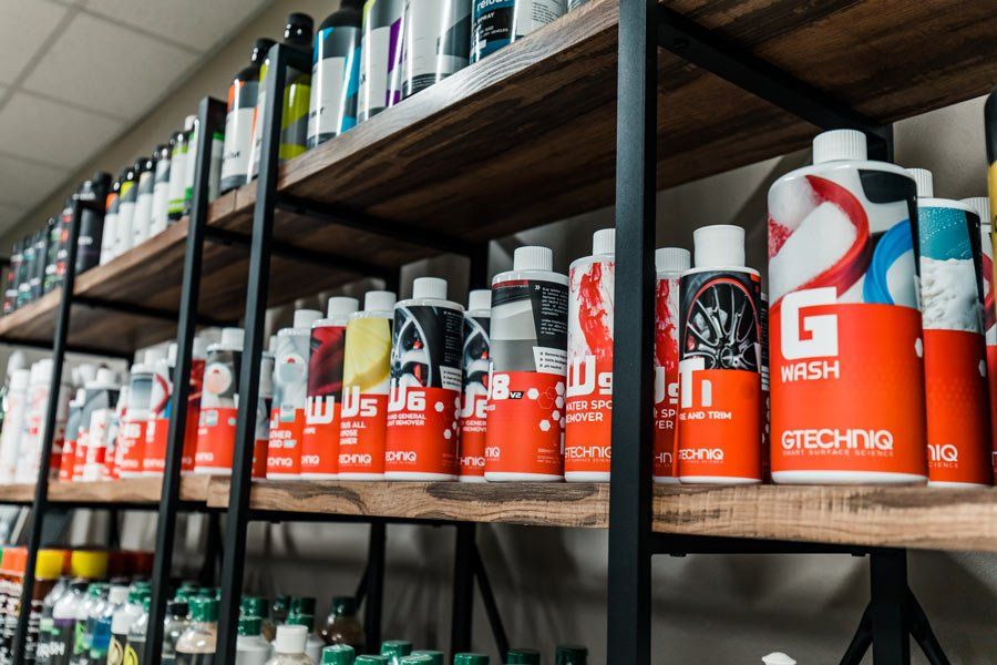 A shelf filled with lots of bottles of cleaning products.