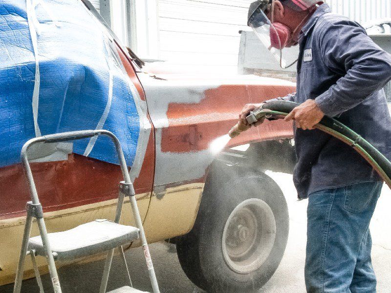 A Man Standing Next to a Red Truck — Indiana, PA — Keystone Dustless Mobile Media Blasting LLC