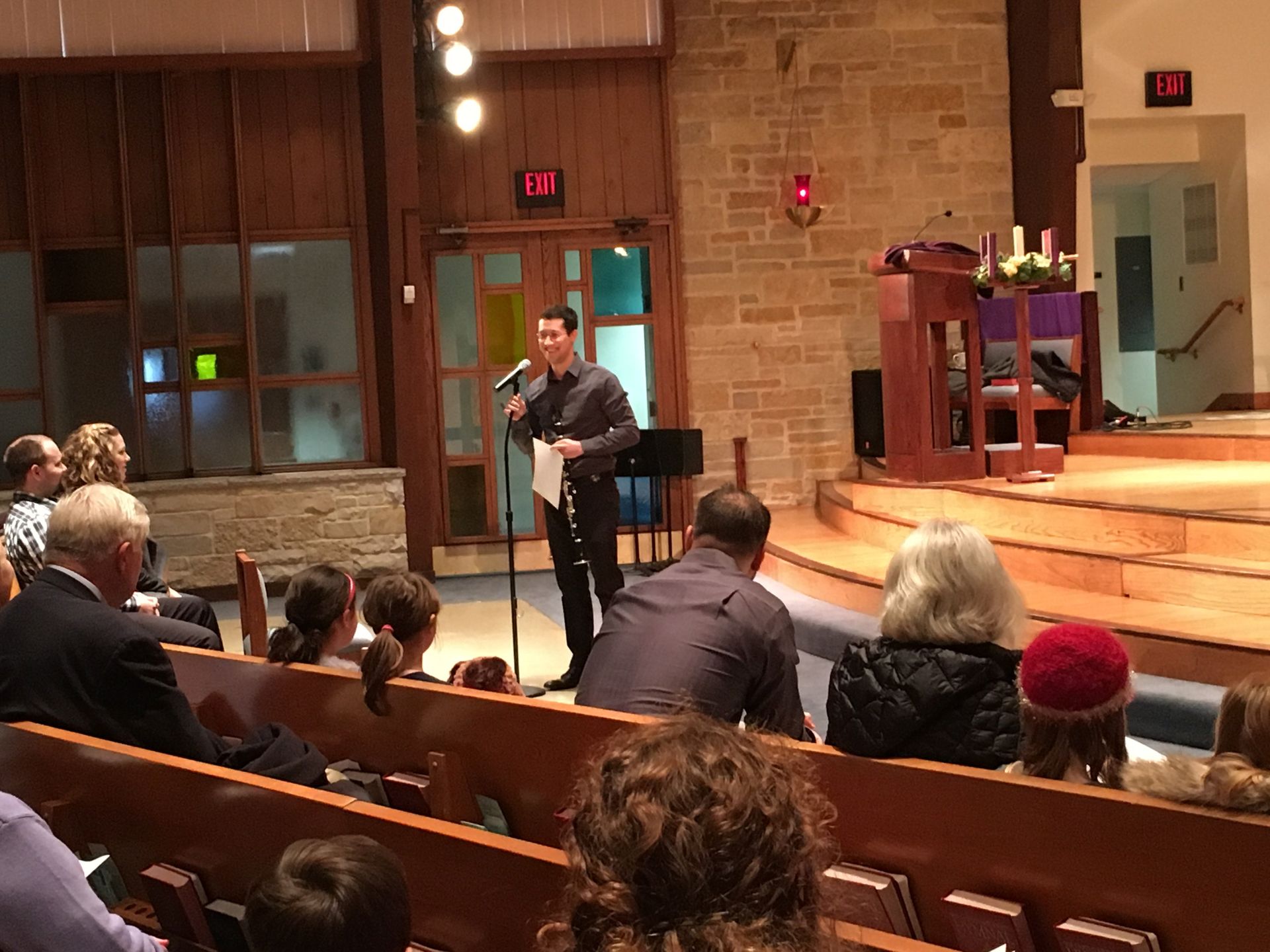Man speaking at a podium in a church, audience seated in pews.
