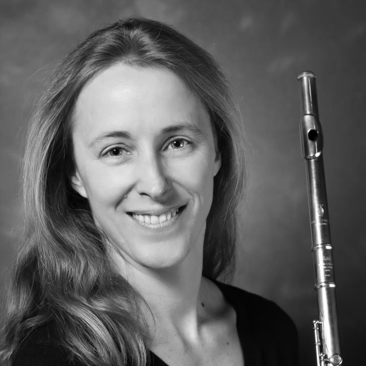 Woman holding a silver flute, smiling, black and white photo.