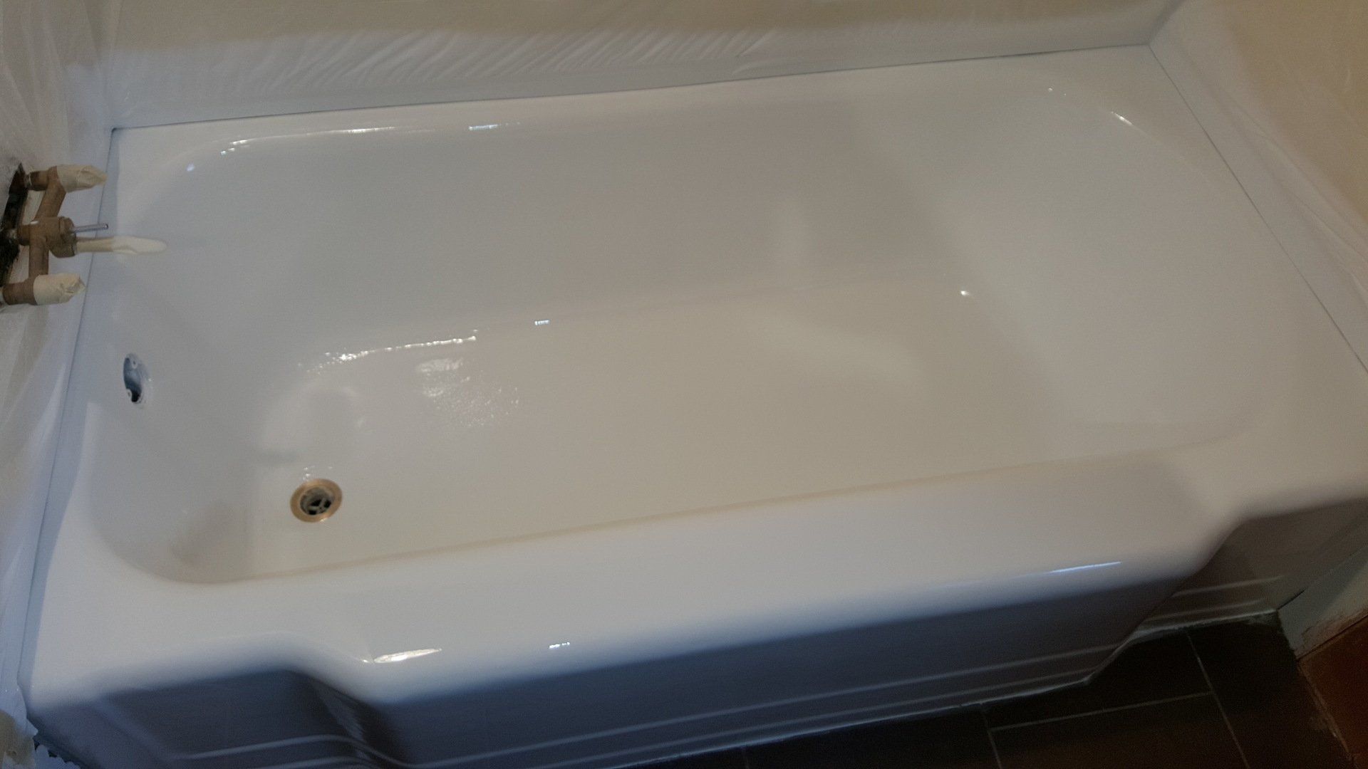 White bathtub with drain, faucet, and edge detail.