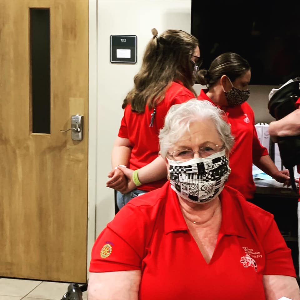 A woman in a red shirt wearing a face mask
