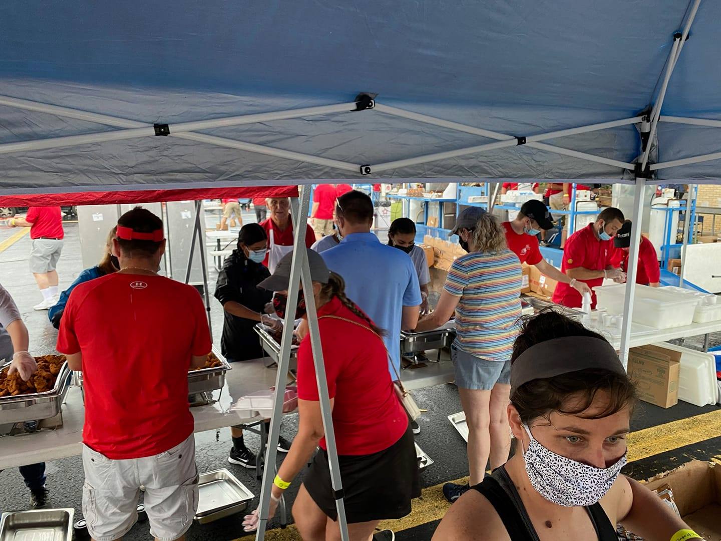 A group of people are standing under a tent.
