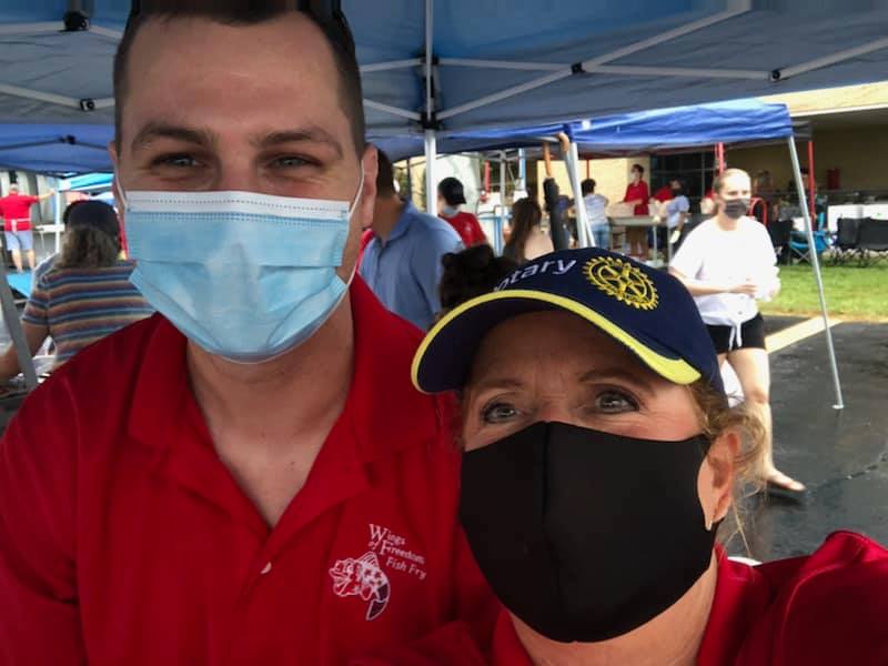 A man and a woman wearing face masks are posing for a picture