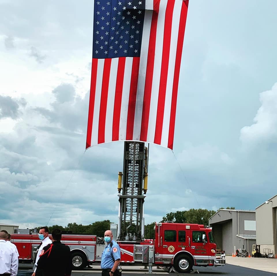 An american flag is hanging from the side of a fire truck