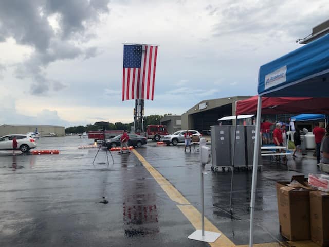 An american flag is hanging from a pole in a parking lot