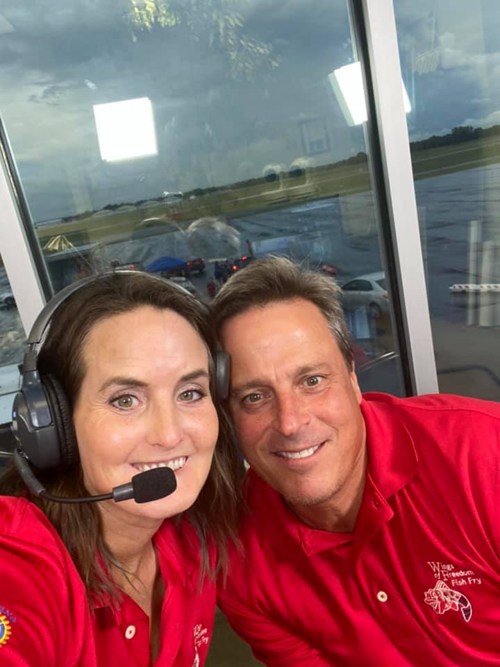 A man and a woman wearing headphones are posing for a picture.