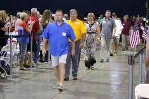 A group of people are walking down a concrete walkway.