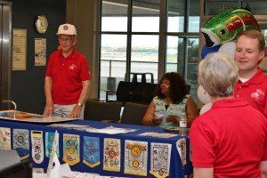 A group of people standing around a table with a blue table cloth