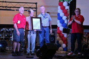 A group of people standing on a stage holding a certificate