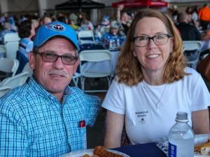 A man and a woman are sitting at a table with a plate of food.