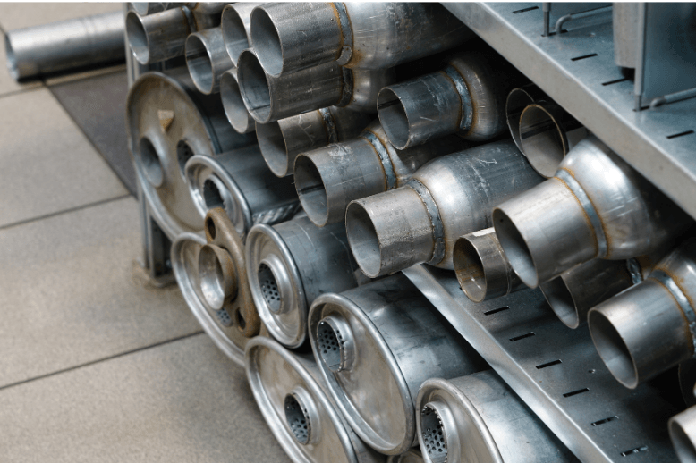 Stacked shiny metal duct pipes on warehouse shelving