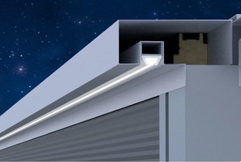 Grondaia e tubo di scarico in metallo su un edificio grigio contro un cielo notturno stellato.