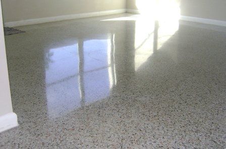Shiny speckled epoxy floor reflecting a sunlit window in an empty room