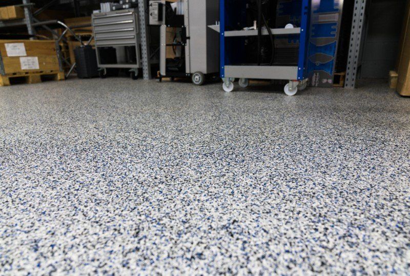 Warehouse floor with speckled epoxy coating and carts against the wall
