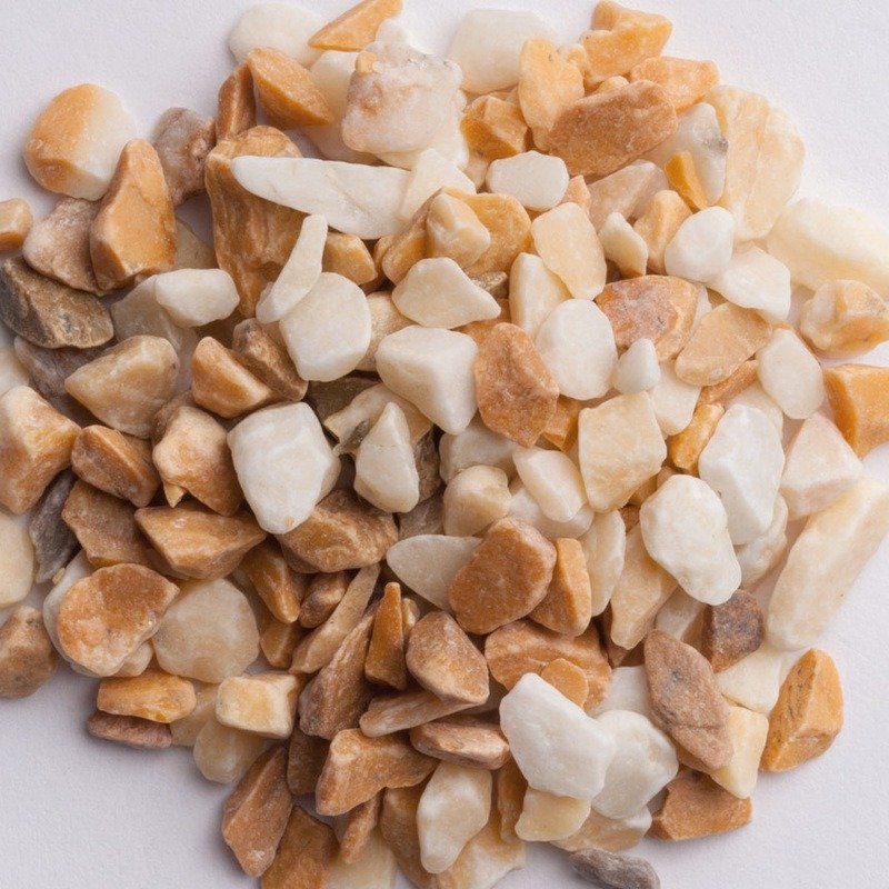 Pile of mixed small pebbles in white, tan, and brown tones on a plain background